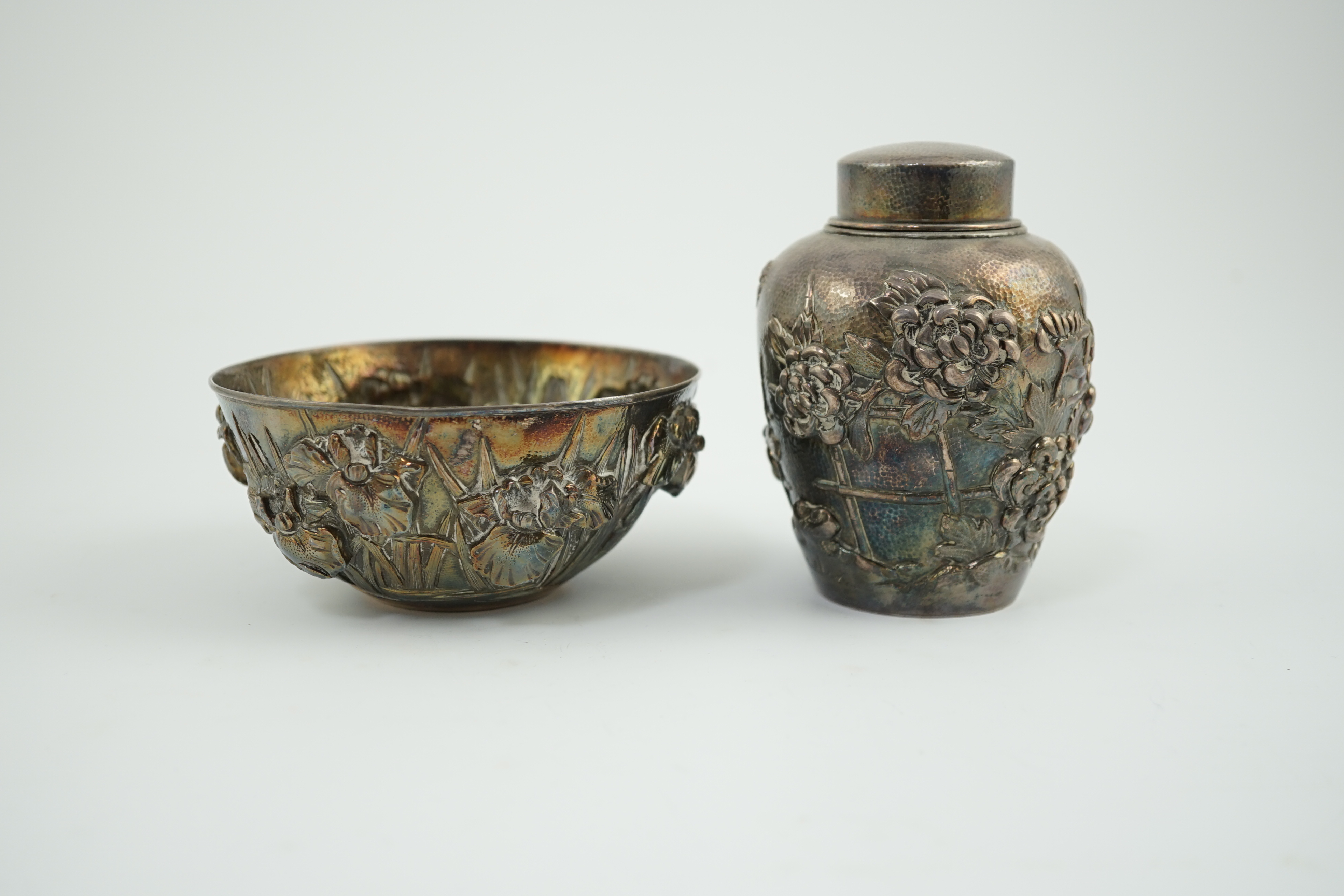 An early 20th century Japanese silver ovoid tea caddy and cover, decorated with prunus, together with a similar Japanese silver bowl